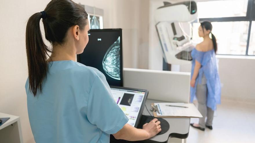Una técnico de radiología realiza una mamografía a una mujer.