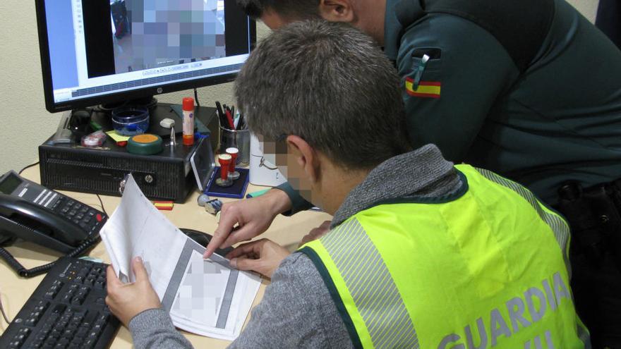 Dos agentes examinan documentación de la investigación.