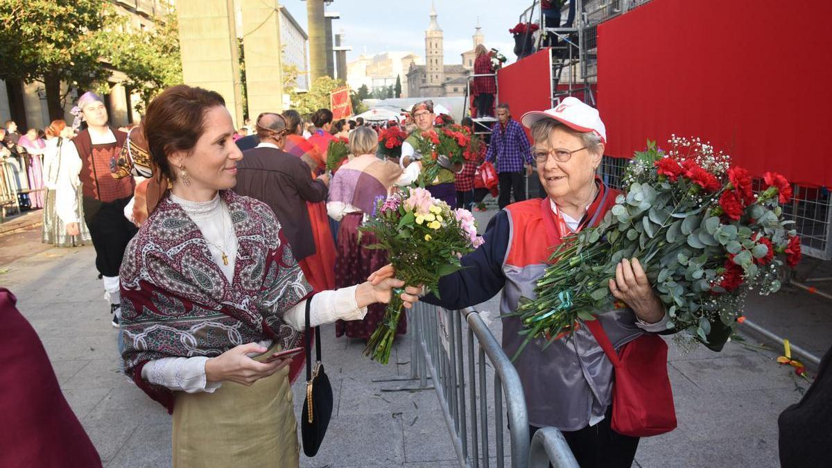 Una voluntaria recogiendo los ramos que serán depositados en el manto de la Virgen.