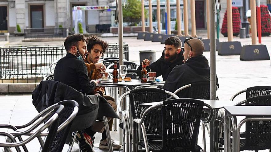 Jóvenes comen churros en la plaza de María Pita. |   // CARLOS PARDELLAS