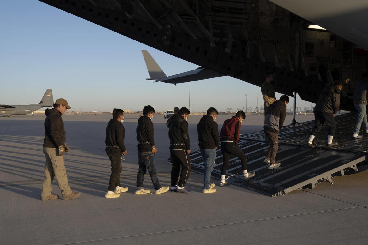 Agentes migratorios de EEUU guían a inmigrantes guatemaltecos a un avión de la Fuerza Aérea de EEUU para su deportación