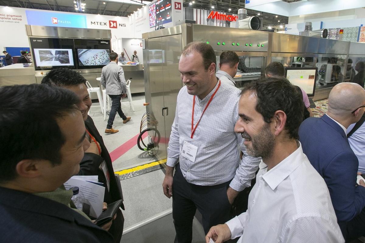 Andrés Cabello, de Kerajet, explica a posibles compradores asiáticos las excelencias de su máquina en ITMA 2019. 