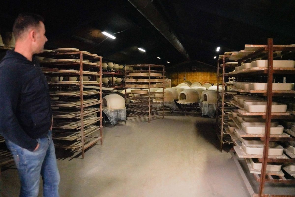 El propietario de la empresa observa los hornos y otras piezas en la nave de secado de la fábrica.