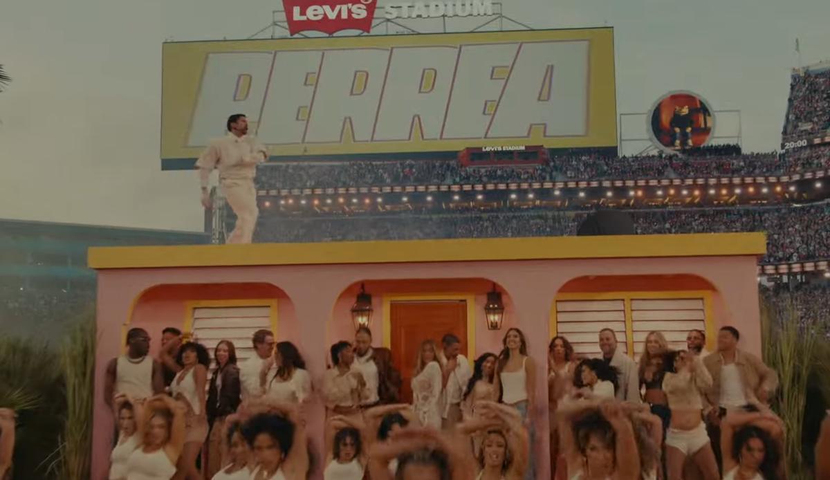Bad Bunny durante un momento de su show, con la palabra "perrea" en la pantalla como parte de la letra de su canción.