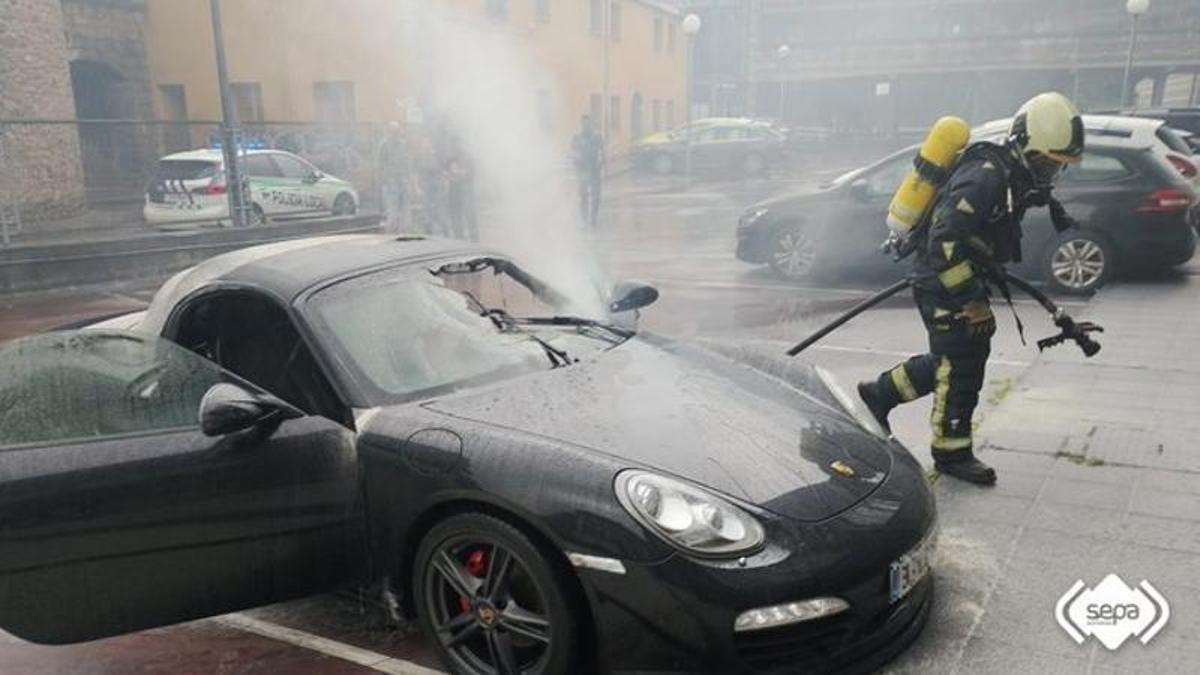 Un bombero interviene en el incendio del Porsche en Langreo.