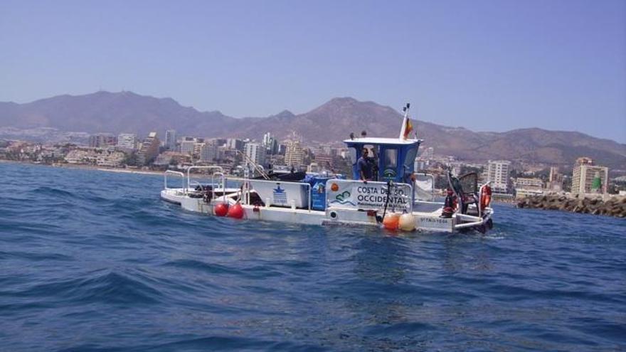 Un barco de la Mancomunidad de Municipios de la Costa del Sol Occidental limpia las aguas.