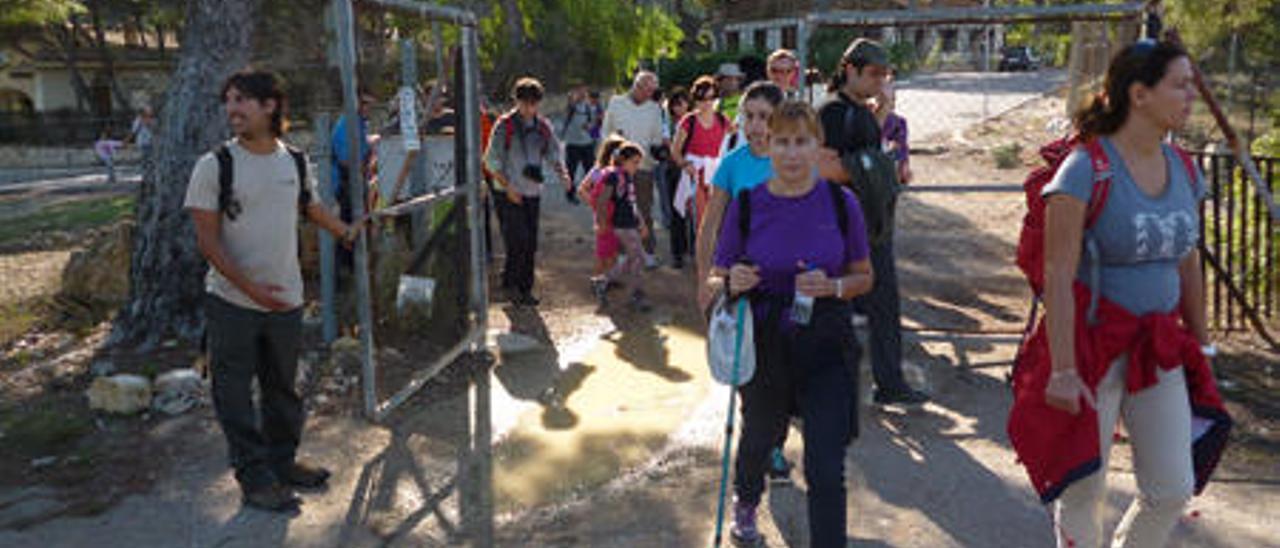 Los excursionistas cruzan la valla para acceder a la zona privada del bosque.