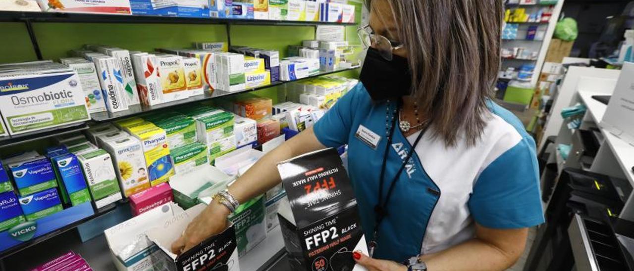 Una trabajadora de la Farmacia Artal reponiendo mascarillas ayer después de Semana Santa se agotaran. | JAIME GALINDO