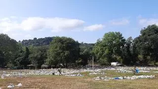 La resaca del Carmín de la Pola: sopladores y palas para recoger montones de basura, buscadores de "tesoros" olvidados y hasta atrapa botellas para revenderlas