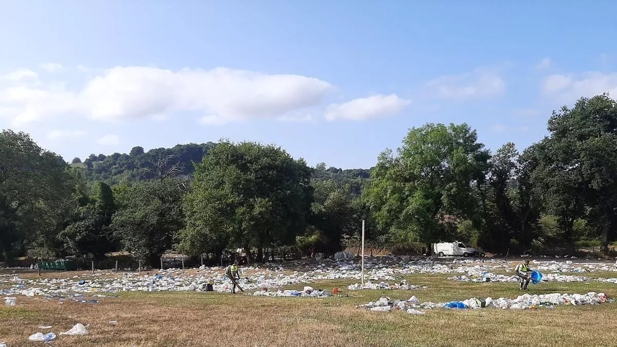 La resaca del Carmín de la Pola: sopladores y palas para recoger montones de basura, buscadores de "tesoros" olvidados y hasta atrapa botellas para revenderlas