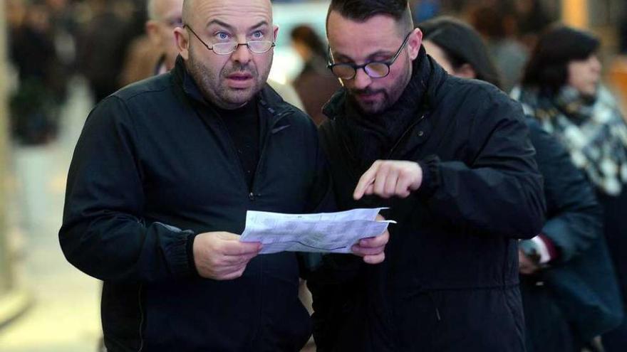 Dos turistas observan un plano de la ciudad en la pasada Semana Santa.  / /Rafa Vázquez.