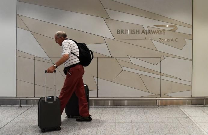 A man arrives at the British Airways check-in ...