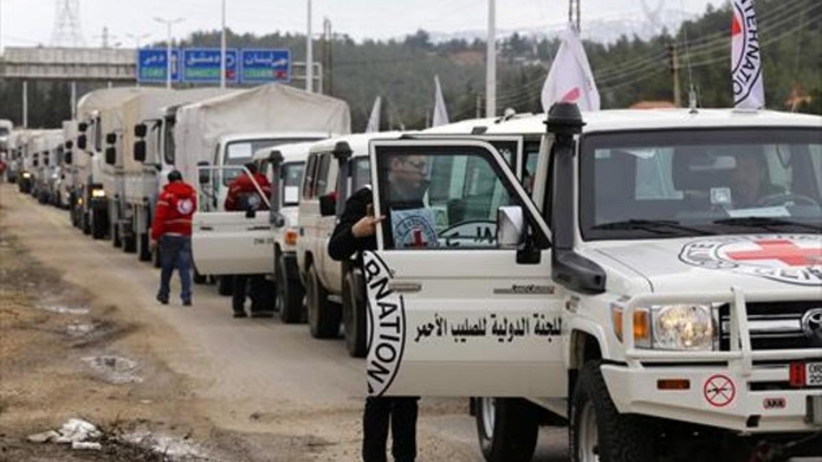 Vehículos con ayuda humanitaria esperan a entrar en la población siria de Madaya.