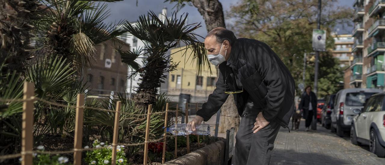 Carlos, vecino de La Bordeta, riega el jardín de la calle Mossèn Amadeu Oller, en Barcelona.