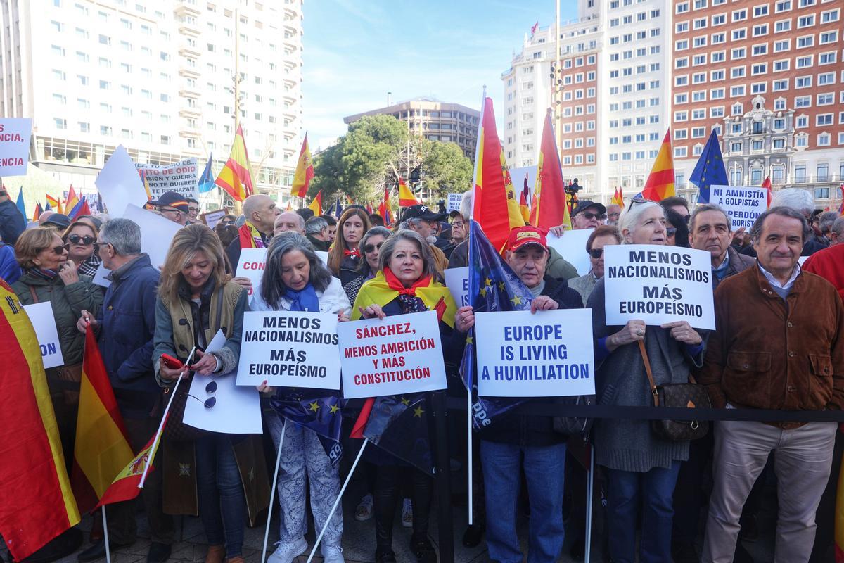 Varias personas sujetan carteles antes de una manifestación convocada por el PP, a 28 de enero de 2024, en Madrid (España).