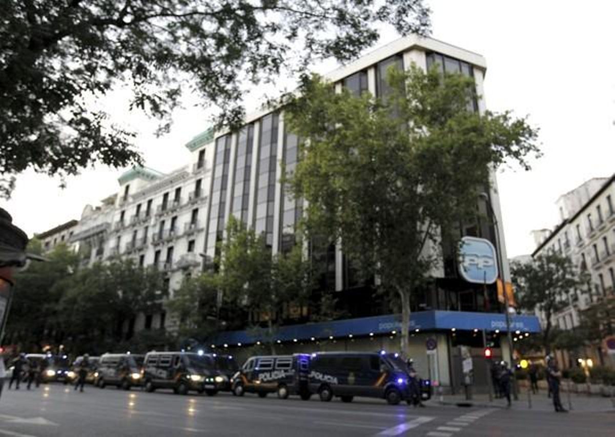 La seu del PP, envoltada de furgons del Cos Nacional de Policia a l’espera de l’arribada dels funcionaris que s’estaven manifestant pels carrers de Madrid diumenge a la tarda.