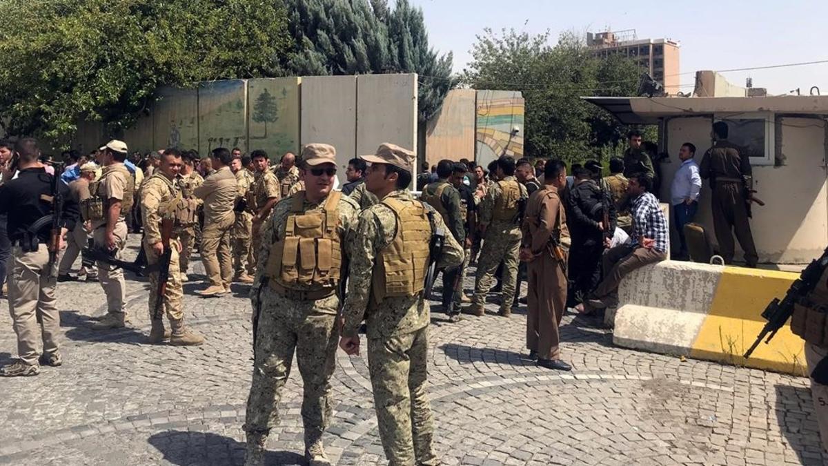 Miembros de las fuerzas de seguridad kurdas fuera del edificio gubernamental asaltado.