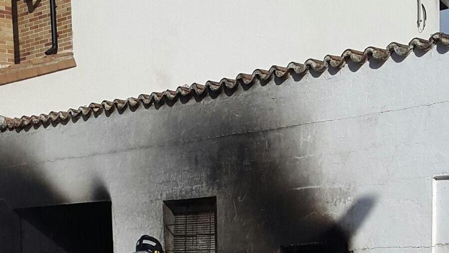 Un bombero trabaja en la vivienda afectada por el fuego.