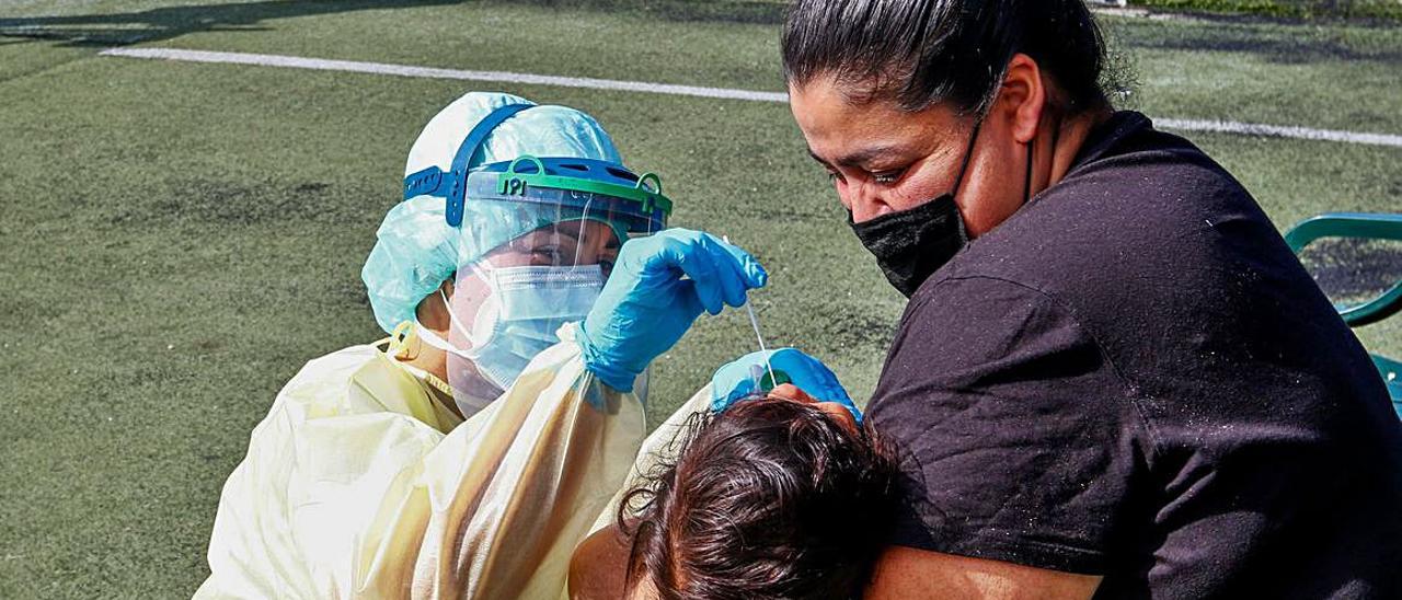 Una madre consuela a su niña durante la prueba PCR