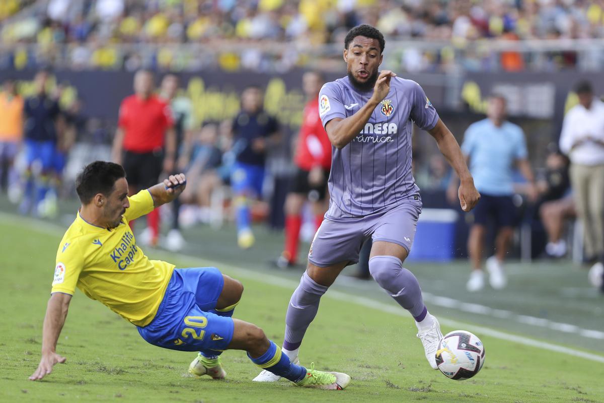 CÁDIZ, 01/10/2022.-  El delantero del Villarreal CF, Arnaut Danjuma, lucha por el balón con el defensa del Cádiz CF, Isaac Carcelén, durante el partido de la jornada 7 de LaLiga Santander disputado este sábado en el Estadio Nuevo Mirandilla de Cádiz. EFE/Román Ríos