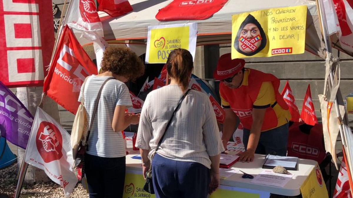 Dos personas se prestan a firmar para apoyar a los empleados de Correos en Tenerife. 