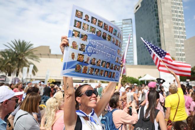 tel aviv (Israel).- A woman holds a placard with photos of Israeli hostages that reads in Hebrew, The Merciful One will raise up for us the fallen tabernacle of David, during a celebration after a peace deal is announced at Hostages Square in Tel Aviv, Israel, 09 October 2025. US President Donald Trump announced that Israel and Hamas have agreed to the first phase of a Gaza peace plan. The deal involves the release of Israeli hostages and Palestinian prisoners, the withdrawal of Israeli forces, and the delivery of humanitarian aid to Gaza.
