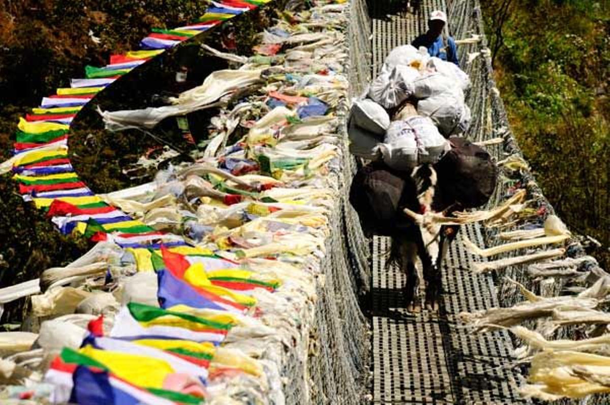 Camino de Namche Bazar hay que cruzar por el vertiginoso puente colgante de Larja, cubierto de multicolores banderas de oraciones que se mueven al viento.