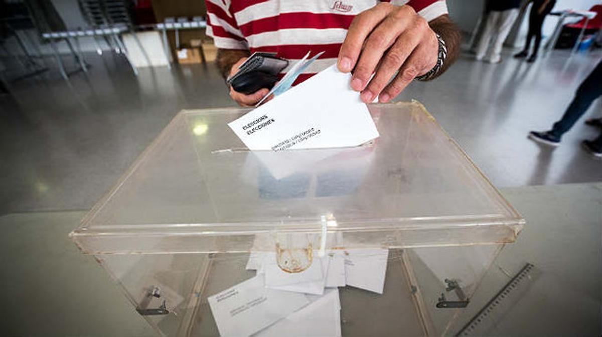 Urna y papeleta en un colegio electoral.