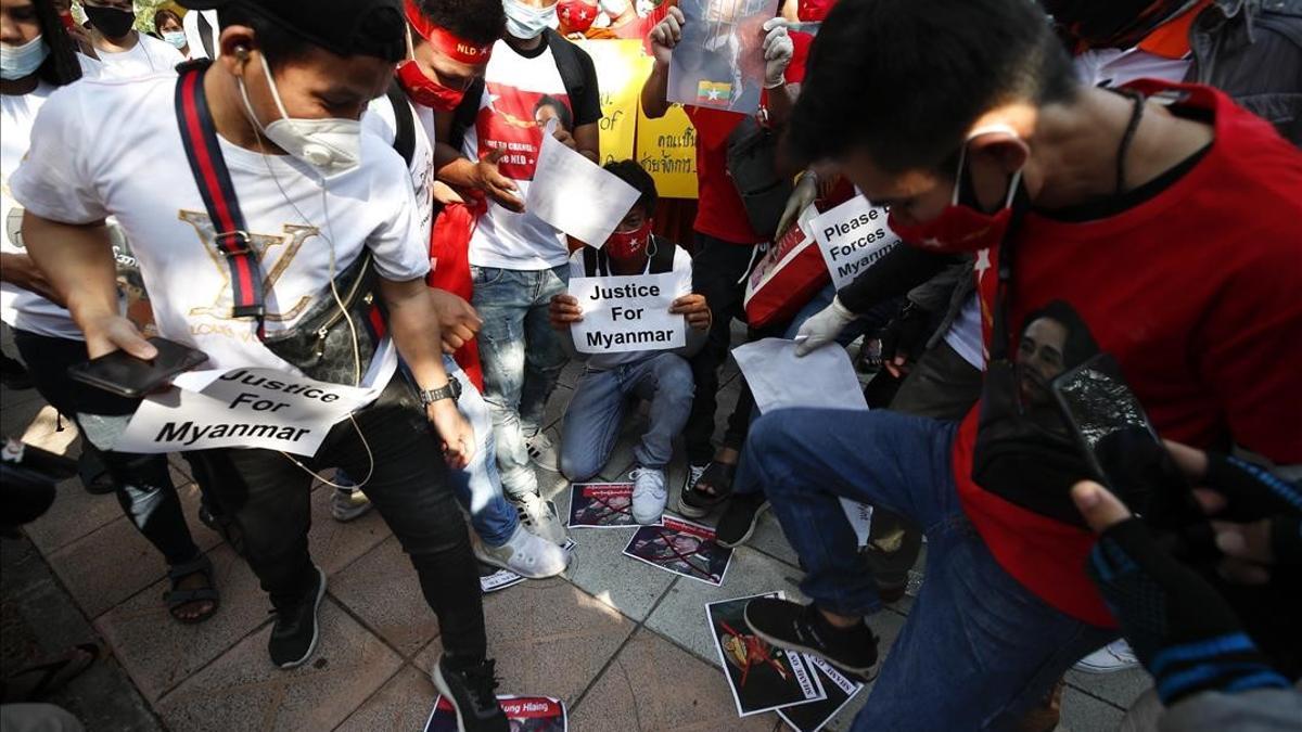 Manifestantes prodemocráticos birmanos pisotean fotografías del jefe del Ejército en Bangkok.