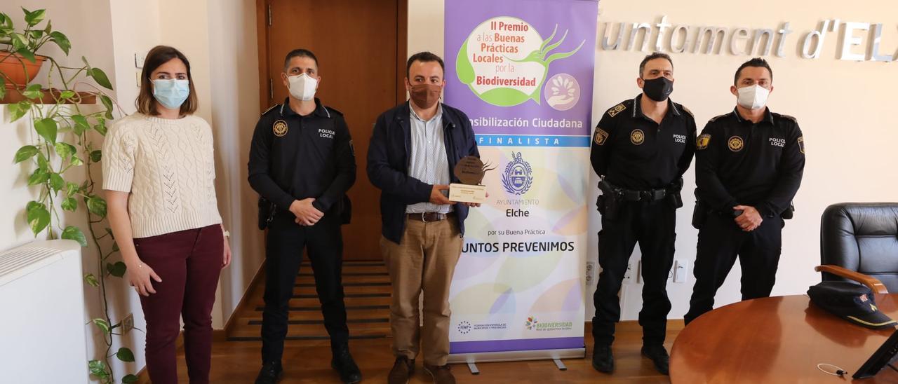 Miembros del equipo de gobierno y de la Policía Local de Elche mostrando el galardón por la sensibilización ambiental