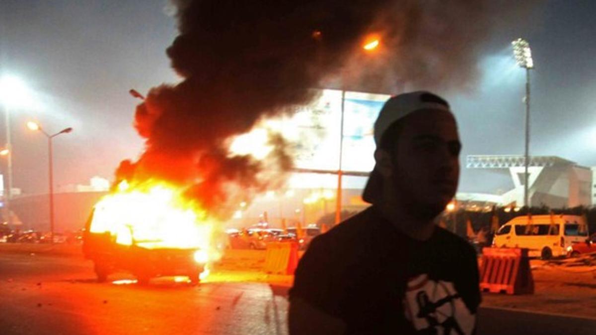 Imágenes de un coche ardiendo este domingo, durante los disturbios en El Cairo.