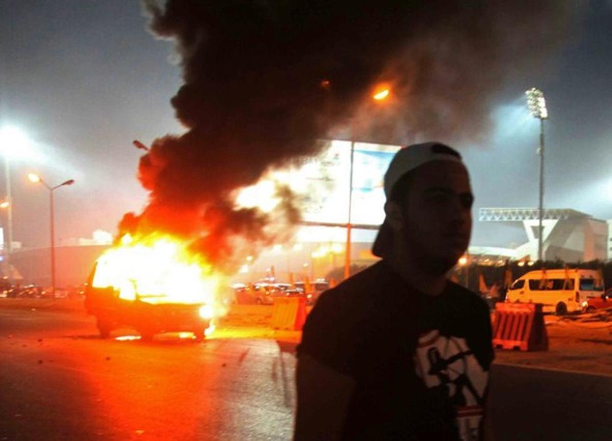 Imágenes de un coche ardiendo este domingo, durante los disturbios en El Cairo.