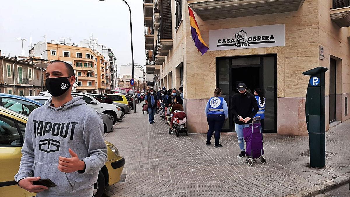 Joan Bonet, uno de los portavoces, con la cola de personas que recogieron alimentos.