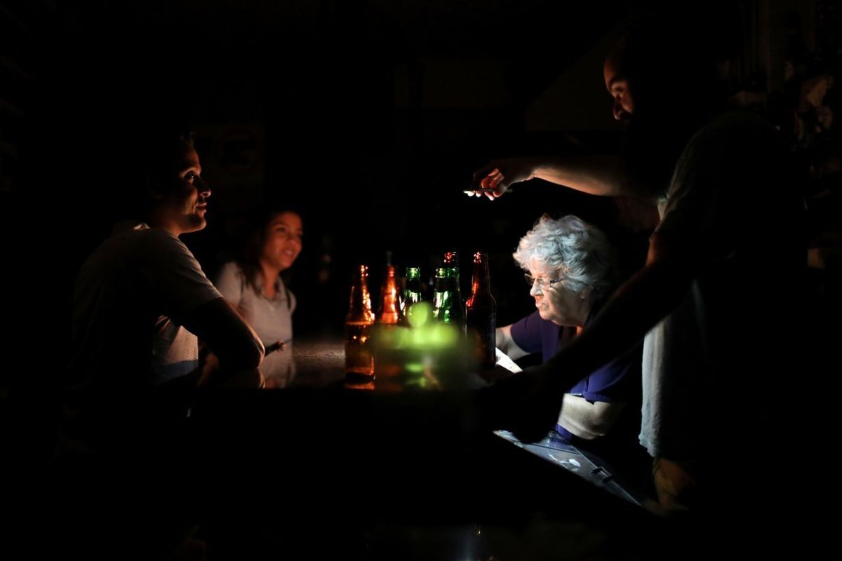 Personas en un bar en pleno apagón eléctrico en Venezuela.