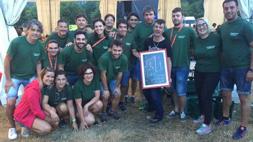 José &quot;El Peñucu&quot;, con el cuadro del cartel, rodeado por miembros de la asociación.