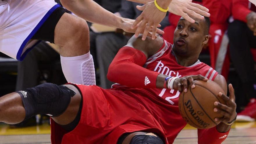 Dwight Howard pelea un balón en el suelo.