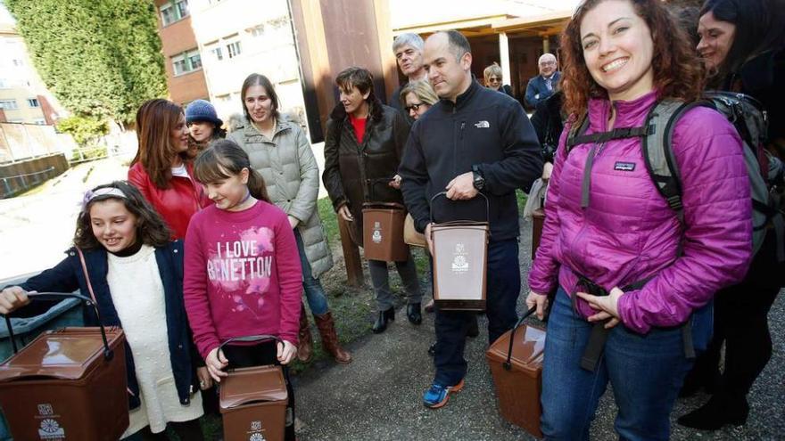 Las familias del Novo Mier, ayer, con los cubos de compostaje que se llevarán a casa.