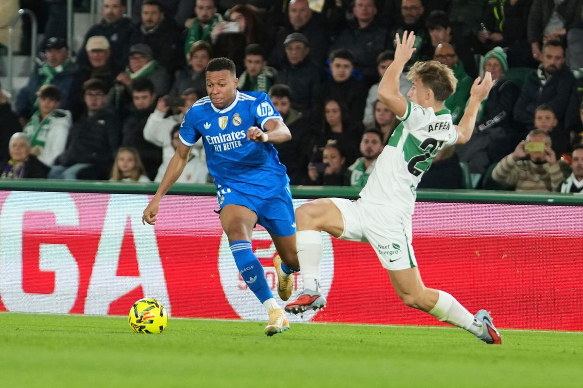 Real Madrid's Kylian Mbappe, left, and Elche's David Affengruber challenge for the ball during the Spanish La Liga soccer match between Elche and Real Madrid in Elche, Spain, Sunday, Nov. 23, 2025. (AP Photo/Alberto Saiz). EDITORIAL USE ONLY/ONLY ITALY AND SPAIN