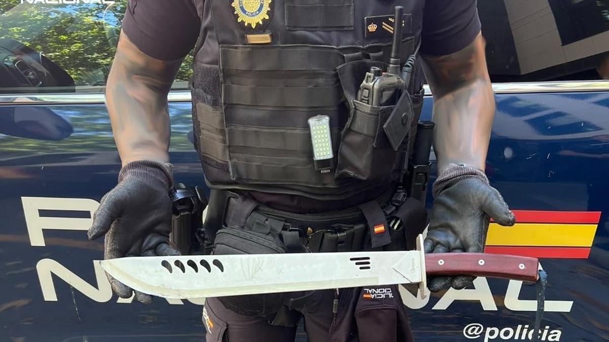 Un agente sostiene el machete de medio metro con el que el matratador amenazó a su expareja.