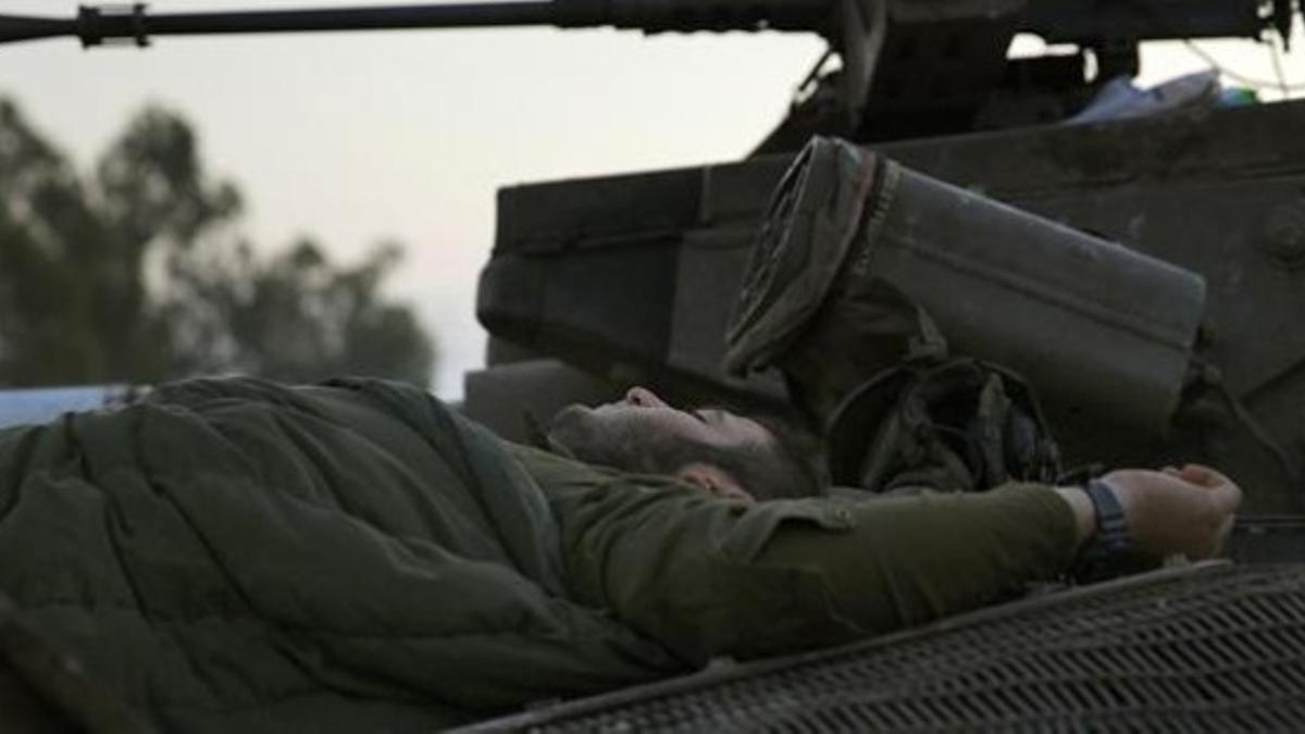 Un soldado israelí duerme sobre un tanque junto a la frontera con Gaza