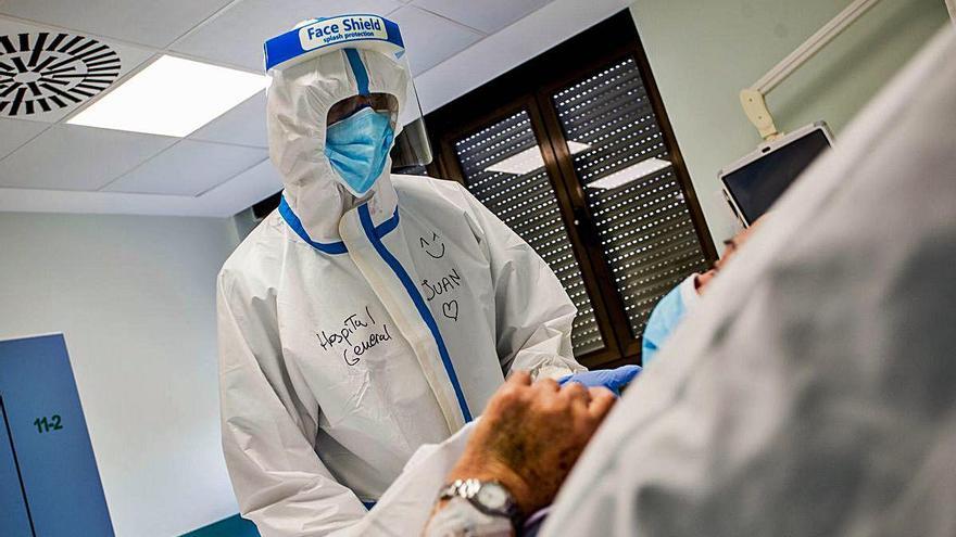 Un profesional sanitario atendiendo a un paciente covid-19 en el Hospital General de València, en una foto de archivo.