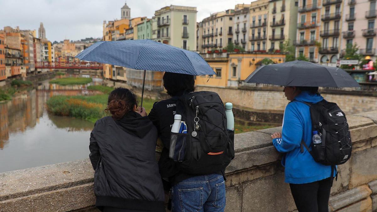 Paseantes bajo la lluvia en Girona