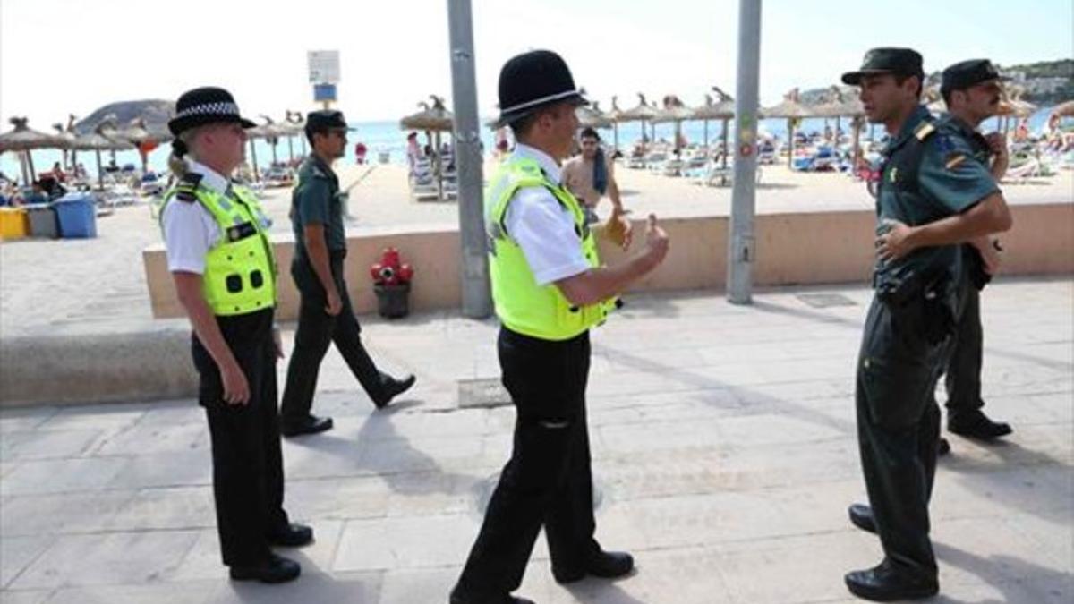 La pareja de policías británicos patrulla conjuntamente con tres guardias civiles por el paseo marítimo de Magaluf, en Mallorca, ayer.