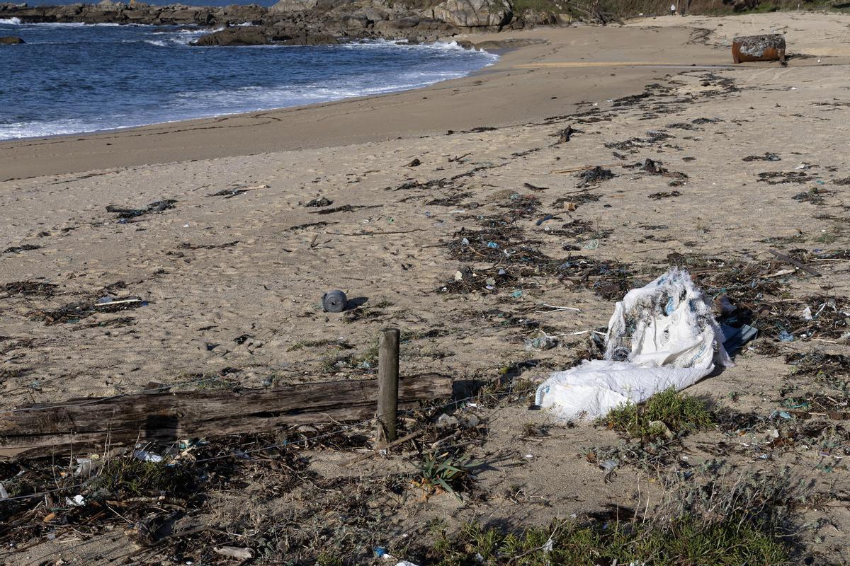 Vista de la foto playa de Area de Bon, donde han llegado este sábado montones de basura procedente del mar