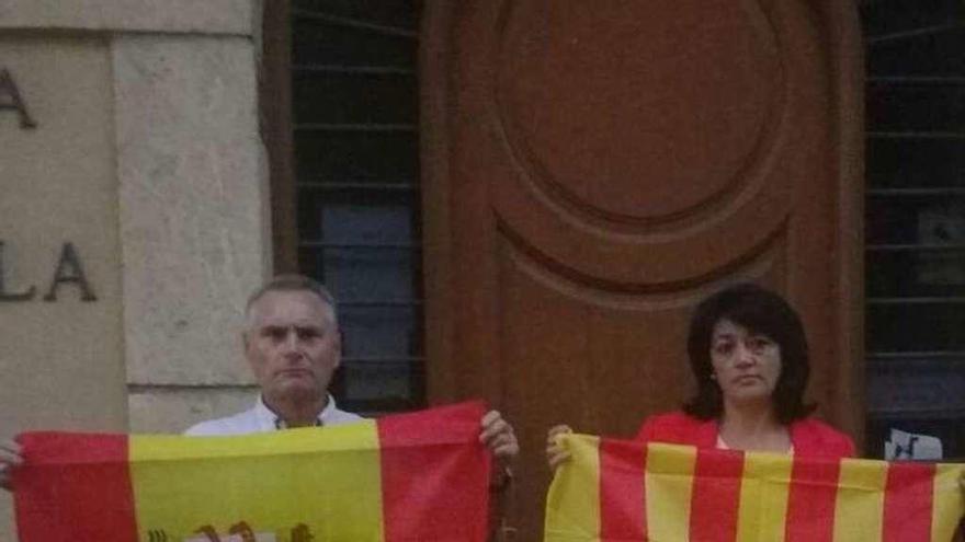 María Juncal con la bandera de Cataluña y el otro edil del PP en Creixell, Pedro J.Martínez, con la de España delante de la Casa de la Vila (sede del consistorio) de Creixell.// M.J.