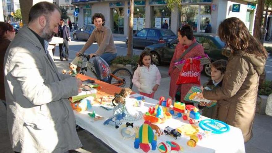 Un hombre atiende un puesto de un mercadillo del trueque organizado por consumidores. / a. p.