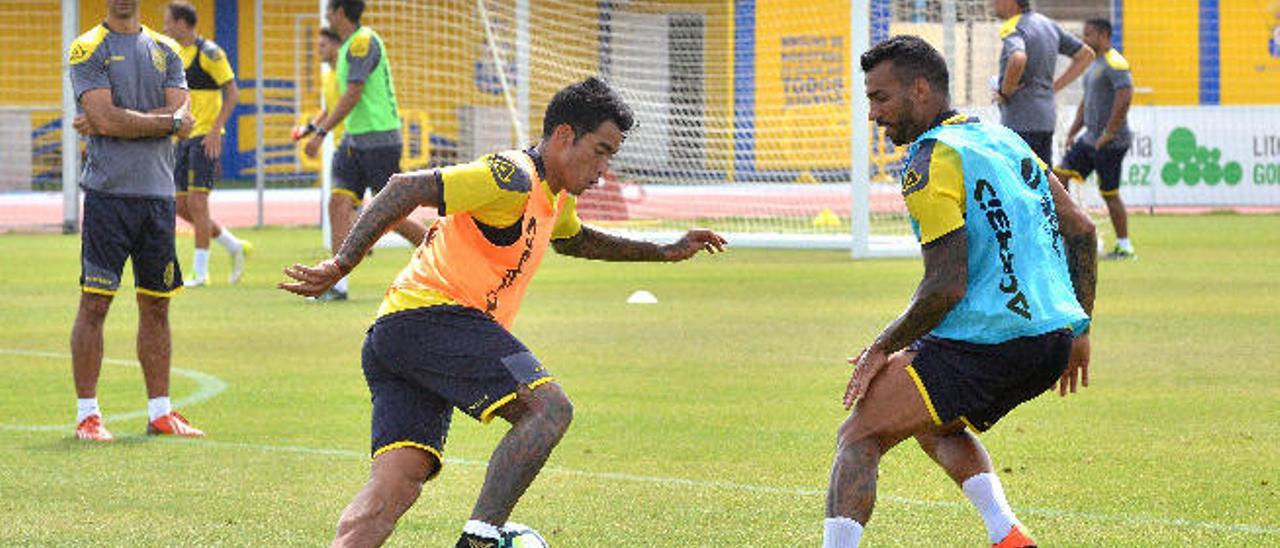 Sergio Araujo, en el entrenamiento de ayer, intenta librarse del lateral Michel Macedo.