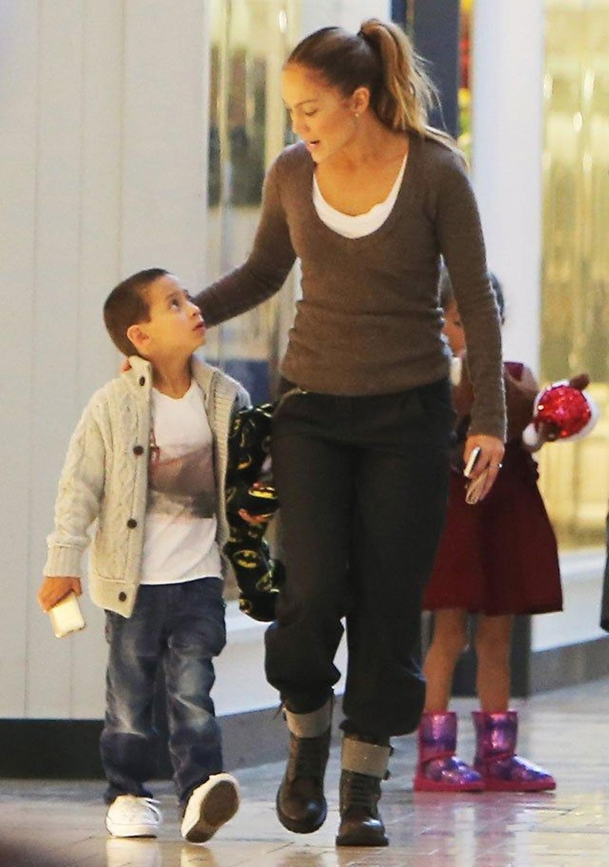 Max y Jennifer Lopez y por detrás Emme en un centro comercial