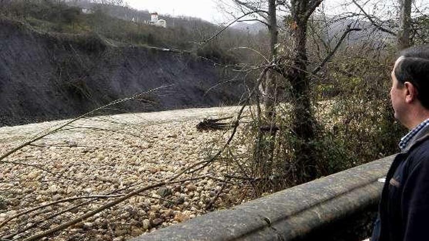 Un vecino mira al otro lado del río la zona del Corredor del Nalón que amenaza con desplomarse en Blimea.