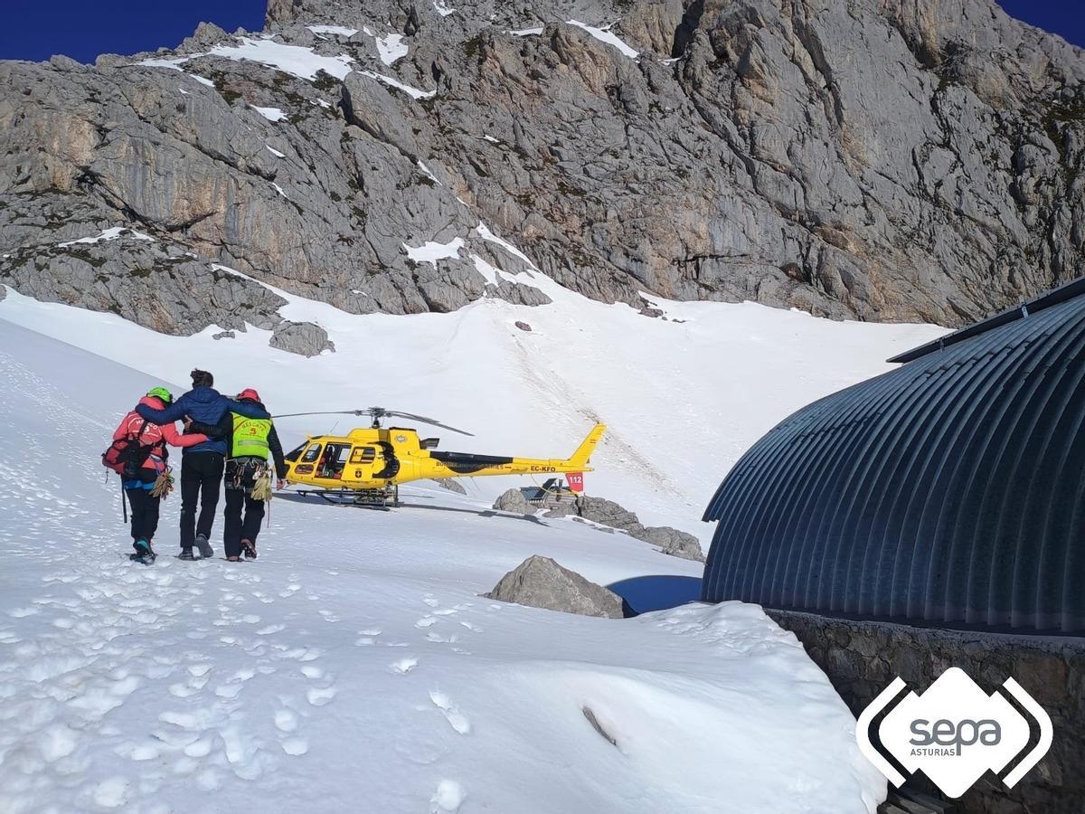 El montañero, en el centro, siendo conducido al helicóptero junto al Refugio de Cabrones.